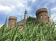 Schloss Moyland hinter hohen Gräsern