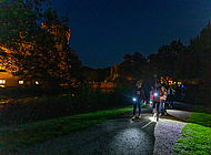 Kinder erkunden mit der Taschenlampe den Schlosspark